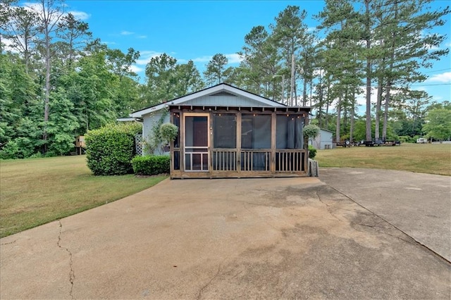 view of side of property with a sunroom and a lawn