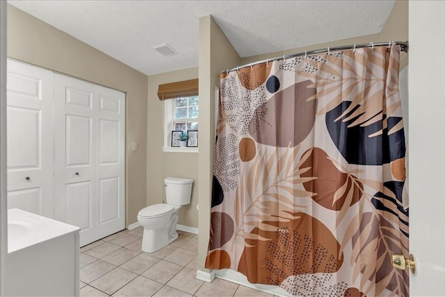 bathroom featuring toilet, tile patterned flooring, walk in shower, a textured ceiling, and vanity