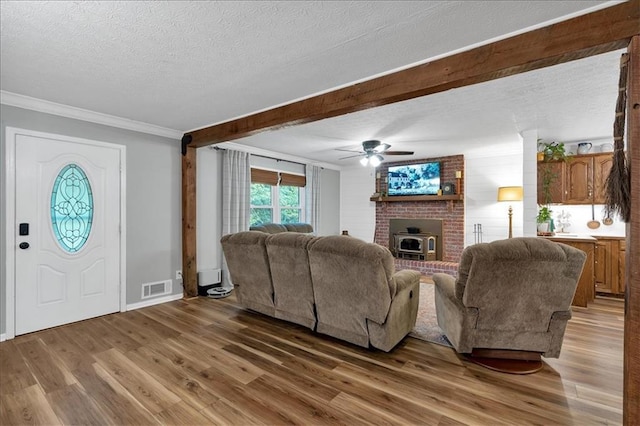 living room featuring ceiling fan, wood-type flooring, crown molding, and a textured ceiling