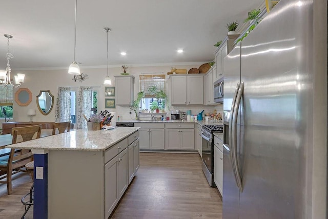 6721 Moondancer Ct, Flowery Branch, GA 30542 - kitchen with appliances with stainless steel finishes, a kitchen island, a breakfast bar, crown molding, and light wood-style floors