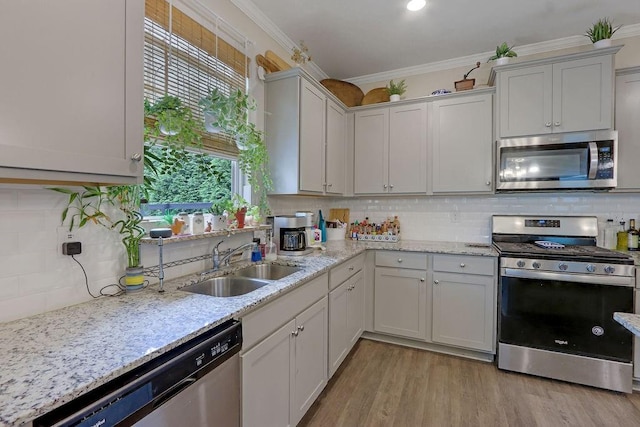 6721 Moondancer Ct, Flowery Branch, GA 30542 - kitchen featuring appliances with stainless steel finishes, a sink, decorative backsplash, healthy amount of natural light, and ornamental molding