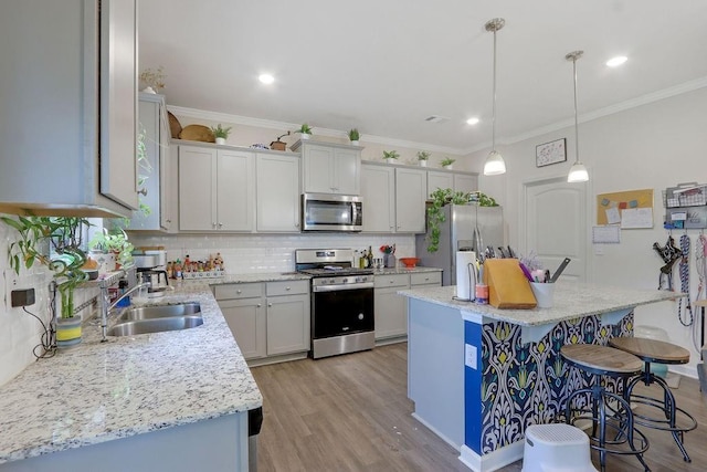 6721 Moondancer Ct, Flowery Branch, GA 30542 - kitchen featuring stainless steel appliances, a kitchen bar, tasteful backsplash, a sink, and light wood-style flooring