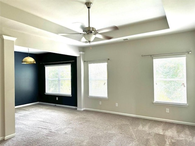 carpeted spare room featuring a wealth of natural light and ceiling fan