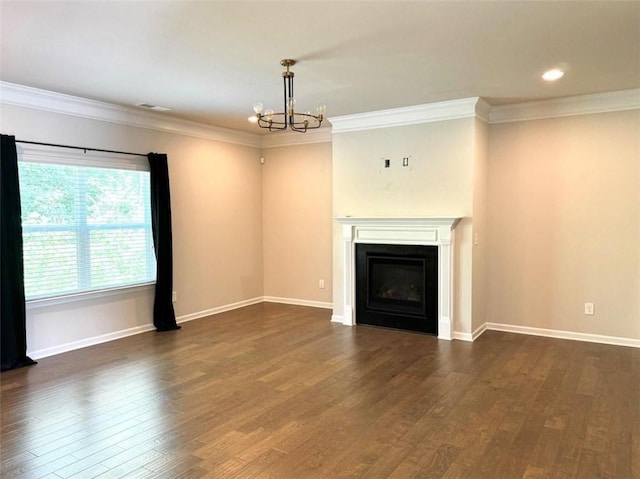 unfurnished living room with crown molding, dark wood-type flooring, and an inviting chandelier