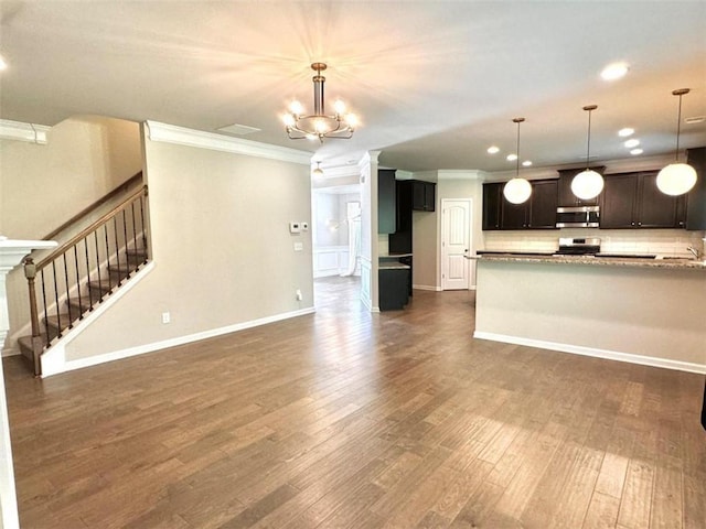 kitchen featuring crown molding, stainless steel appliances, decorative light fixtures, and a notable chandelier