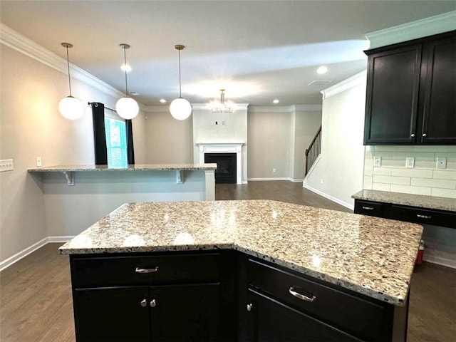 kitchen featuring decorative light fixtures, dark hardwood / wood-style flooring, tasteful backsplash, and a kitchen island