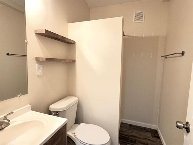 bathroom with wood-type flooring, vanity, and toilet