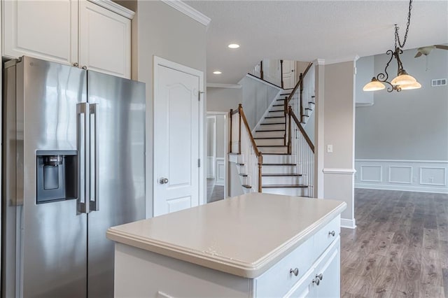 kitchen featuring pendant lighting, white cabinetry, ornamental molding, stainless steel fridge with ice dispenser, and light wood-type flooring