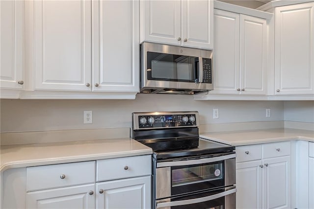 kitchen with white cabinets and appliances with stainless steel finishes