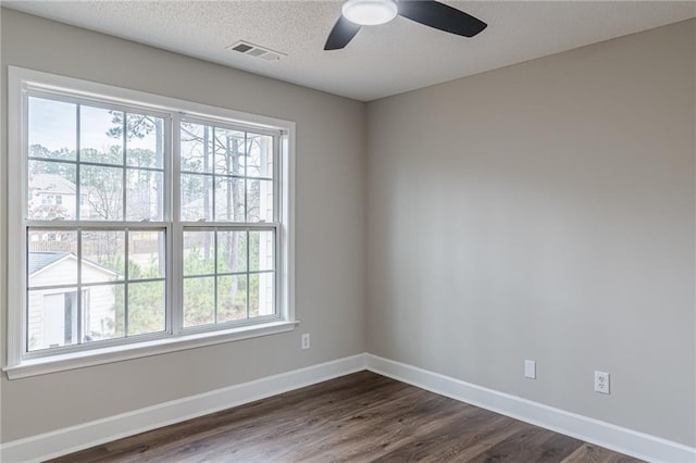 spare room with ceiling fan, a textured ceiling, and dark hardwood / wood-style flooring