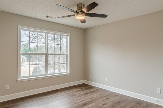 unfurnished room featuring ceiling fan, hardwood / wood-style flooring, a textured ceiling, and a healthy amount of sunlight