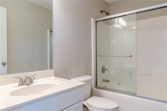 full bathroom with vanity, toilet, and combined bath / shower with glass door