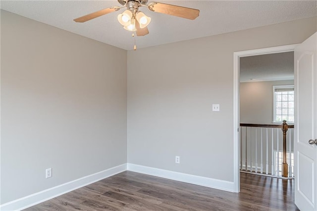 spare room with dark wood-type flooring and ceiling fan