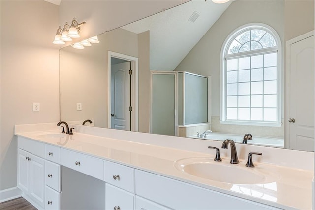 bathroom with independent shower and bath, vaulted ceiling, and vanity