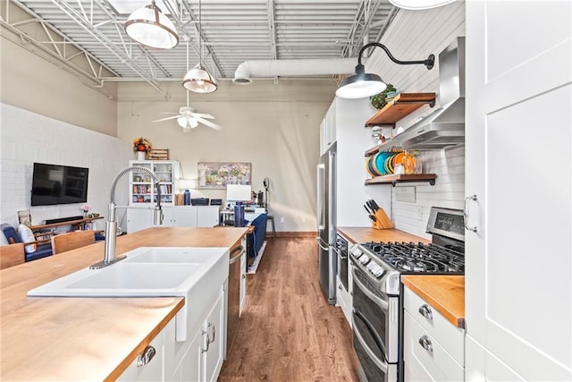 5097 Peachtree Rd Unit I, Atlanta, GA 30341 - kitchen with stainless steel appliances, butcher block counters, open shelves, ceiling fan, and white cabinetry