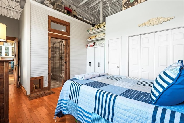 5097 Peachtree Rd Unit I, Atlanta, GA 30341 - bedroom with hardwood / wood-style floors, wood walls, a closet, and connected bathroom