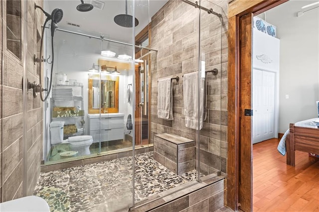 5097 Peachtree Rd Unit I, Atlanta, GA 30341 - bathroom with toilet, a stall shower, wood finished floors, and vanity