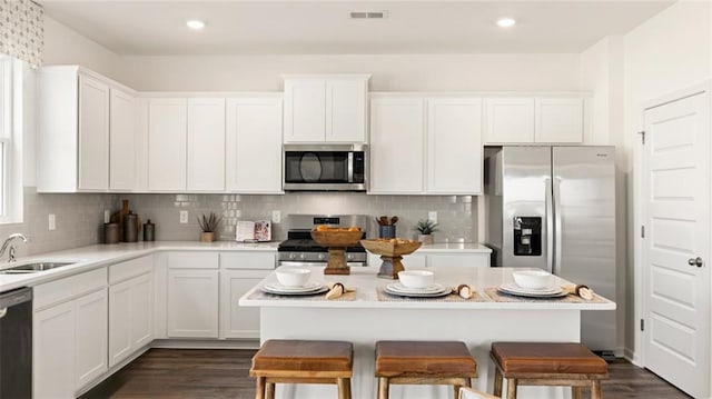 kitchen featuring decorative backsplash, dark wood-type flooring, sink, white cabinetry, and appliances with stainless steel finishes