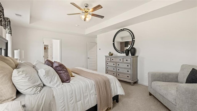 carpeted bedroom featuring ceiling fan and a raised ceiling