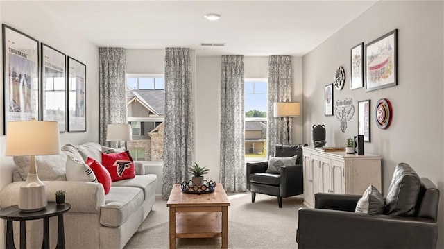 sitting room featuring light colored carpet and plenty of natural light