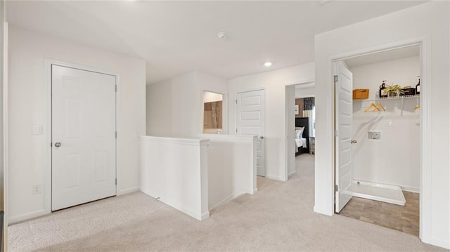 hallway with light colored carpet