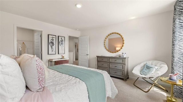 bedroom featuring a closet, light carpet, and a walk in closet