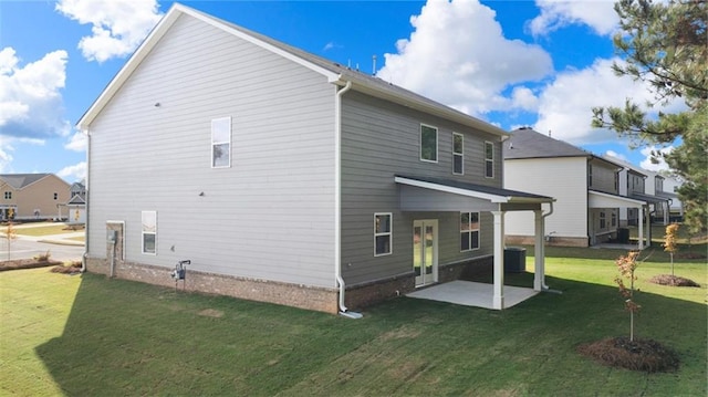 back of property with a patio area, central air condition unit, and a lawn