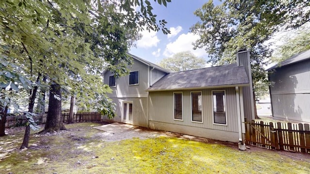1169 Oaks Pl, Stone Mountain, GA 30083 - back of property with a chimney, a fenced backyard, and a shingled roof