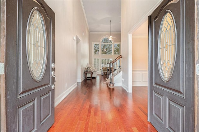 entryway featuring ceiling fan, wood-type flooring, and ornamental molding