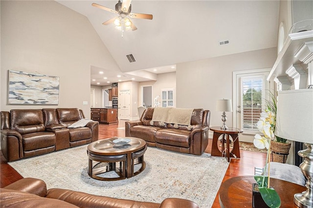 living room featuring ceiling fan, wood-type flooring, and high vaulted ceiling