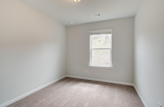 carpeted empty room with visible vents and baseboards