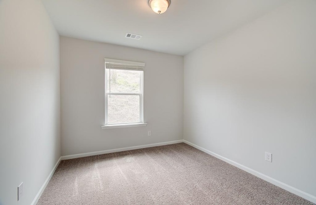 carpeted empty room featuring visible vents and baseboards