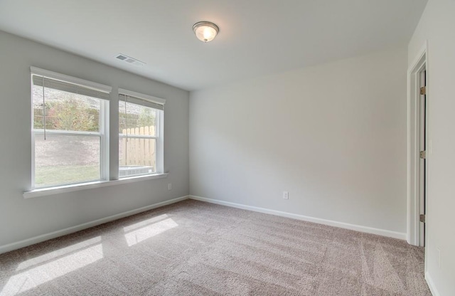 carpeted empty room with visible vents and baseboards