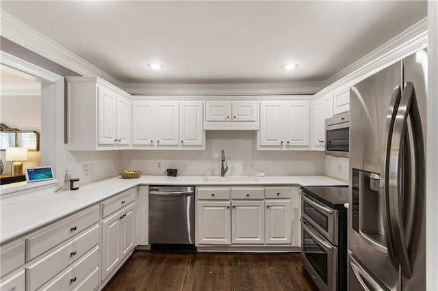 1634 Ponce De Leon Ave Unit 107, Atlanta, GA 30307 - kitchen featuring stainless steel appliances, a sink, white cabinetry, light countertops, and crown molding