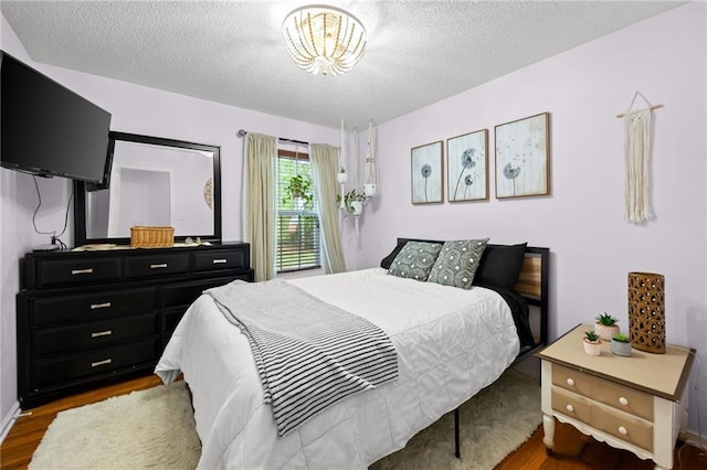 69 Due W Pass, Dallas, GA 30157 - bedroom with wood finished floors, a textured ceiling, and an inviting chandelier