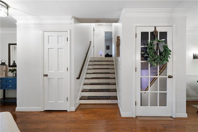 stairway with baseboards, ornamental molding, and wood finished floors