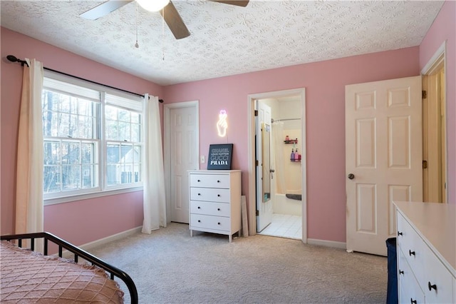 bedroom with ceiling fan, a textured ceiling, connected bathroom, light carpet, and baseboards