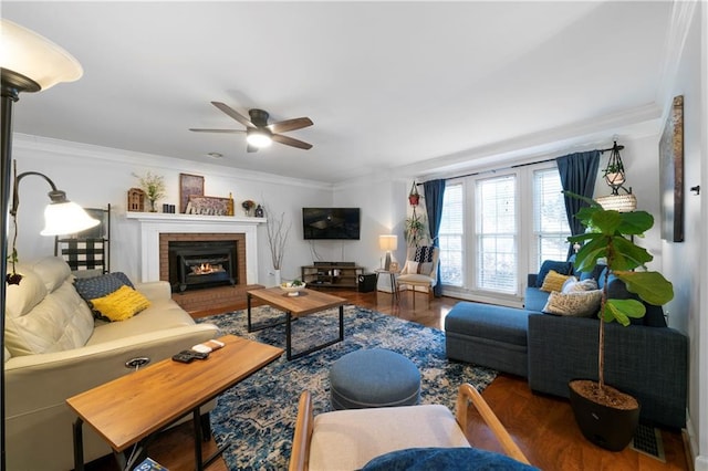 living area featuring a ceiling fan, a brick fireplace, visible vents, and crown molding