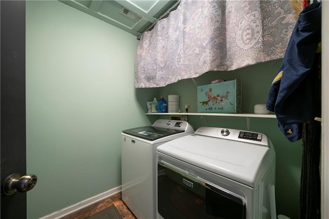 clothes washing area featuring laundry area, washing machine and clothes dryer, and baseboards