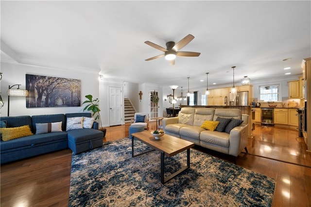 living area with beverage cooler, ornamental molding, stairs, and hardwood / wood-style flooring