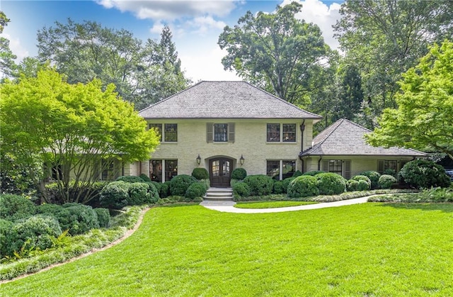 colonial inspired home featuring a front yard and french doors