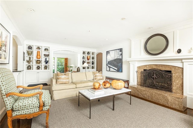 living room with crown molding and a premium fireplace