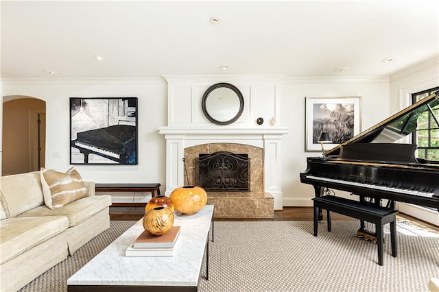 living room with light wood-type flooring, ornamental molding, and a fireplace