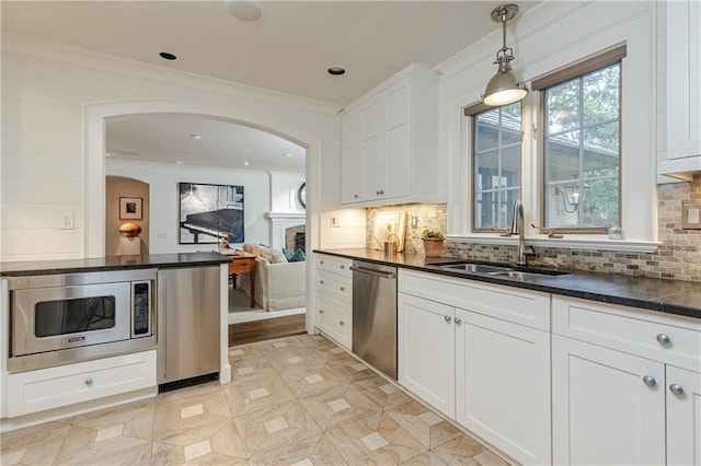 kitchen featuring decorative backsplash, appliances with stainless steel finishes, white cabinetry, and sink