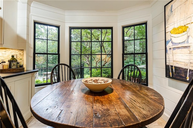 dining area with bar area and crown molding