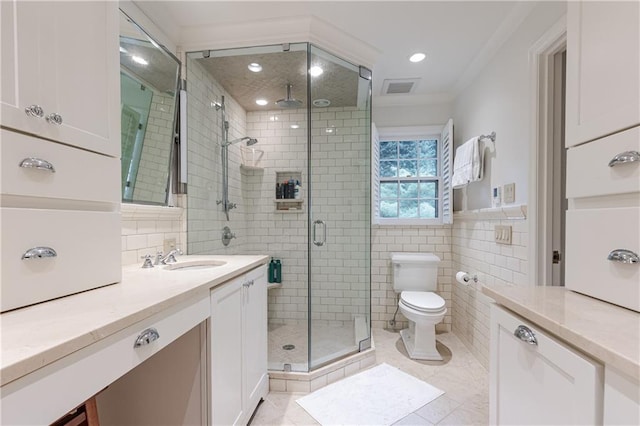 bathroom featuring tile patterned floors, vanity, toilet, and a shower with door