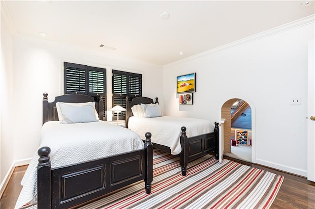 bedroom featuring crown molding and dark wood-type flooring