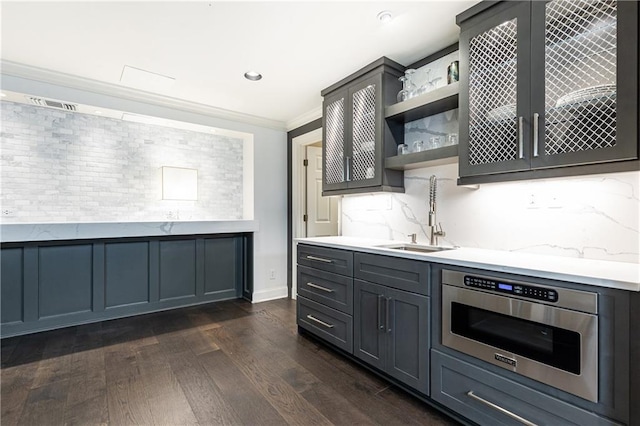 kitchen featuring gray cabinetry, sink, tasteful backsplash, dark hardwood / wood-style flooring, and crown molding