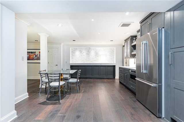 kitchen with gray cabinetry, dark wood-type flooring, crown molding, ornate columns, and appliances with stainless steel finishes