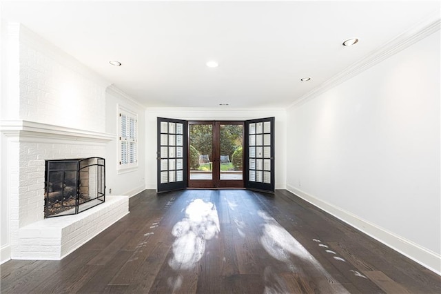 unfurnished living room with a fireplace, french doors, dark hardwood / wood-style floors, and crown molding